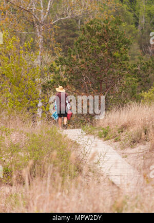 Un homme marche le long d'une promenade de la plage de retour à sa voiture au parc provincial Port Burwell. Banque D'Images