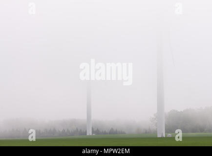 Deux éoliennes de l'Erie Shores Wind Farm sont visibles dans l'orge faible brouillard sur une journée de printemps dans le sud-ouest de l'Ontario, Canada. Banque D'Images