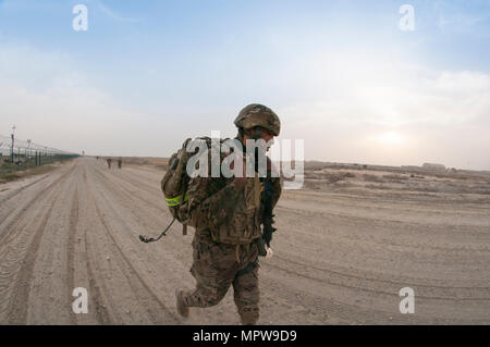 Le Sgt. Calvin Grimes, un soldat avec le 595th bataillon de transport, pousse vers la ligne d'arrivée de la 1ère Commande de soutien (Théâtre) Meilleur guerrier concurrence 10-mile ruck mars au Camp Arifjan, au Koweït le 16 avril, 2017. (Photo par le Sgt. Christopher Bigelow) Banque D'Images