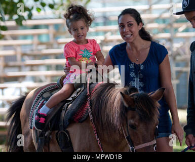 SCHOFIELD BARRACKS - Savannah Wilson prend un tour de poney, accompagnée par sa mère au cours de la 23e Fun Fest, le jour de la Terre et de loisirs Service voyage Travel Fair à Weyand, 15 avril, 2017. Divers programmes, les ministères et les fournisseurs ont été présentés à l'événement, qui est organisé par la Direction de la famille et le moral, de bien-être et de loisirs. La Fun Fest a célébré la Journée de la Terre et de Pâques. (U.S. Photo de l'Armée de Kristen Wong, Oahu Publications) Banque D'Images