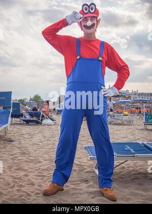 RIMINI, ITALIE - 22 juillet 2017 : Jeune homme cosplayeur dans le costume Mario posant sur la plage Banque D'Images