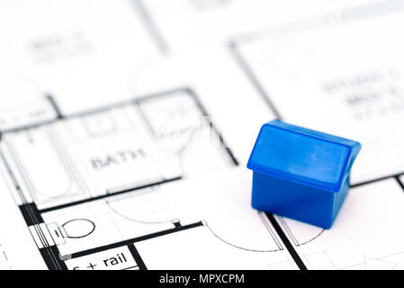 Macro close up d'une maison miniature reposant sur les plans / Schéma Banque D'Images