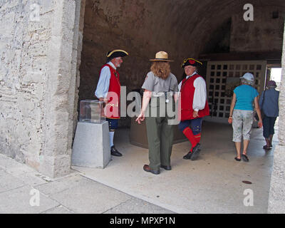 Soldat britannique de reconstitution historique, ranger du parc, et les touristes à Castillo de San Marcos, Saint Augustine, Floride, USA, 2018, © Katharine Andriotis Banque D'Images