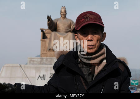 Un vieil homme coréen avec la statue de Sejong le grand roi à Gwanghwamun Plaza dans la ville de Séoul capitale de la Corée du Sud Banque D'Images