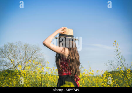 Side view of teenage girl wearing hat en se tenant sur le field au cours de journée ensoleillée Banque D'Images