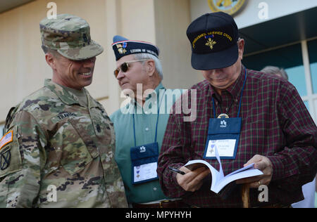 Le Commandement de l'armée américaine le Sgt. Le major Stephen Travers, les capacités de l'Armée de terre Centre d'intégration de sergent-major de commandement, demande de l'Armée américaine à la retraite 1er Sgt. Claude, rapide, membre de la Légion de la vaillance de signer 'courage au combat : Histoires de et sur les bénéficiaires de la plus haute des décorations, un livre écrit par les membres de la Légion de vaillance au cours d'une visite à Joint Base Langley-Eustis, en Virginie, le 21 avril 2017. Recherche rapide a été présenté la Croix du service distingué dans le hall d'honneur de Washington, D.C., 25 ans après avoir pris sa retraite de l'armée. (U.S. Air Force photo/Navigant de première classe Kaylee Dubois) Banque D'Images