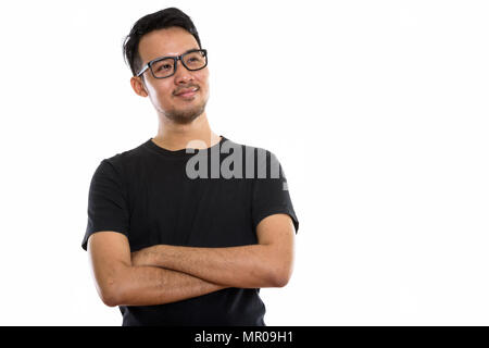 Studio shot of young Asian man thinking while wearing eyeglasses Banque D'Images