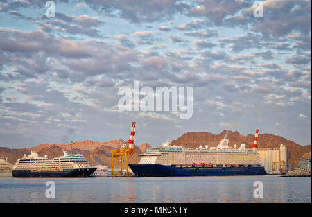 Deux majestueux navires de croisière amarré dans le port avec des montagnes en arrière-plan et un ciel dramatique au-dessus de eux. Coup de Muscat, Oman. Banque D'Images