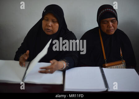 Les femmes aveugles musulmans vu la lecture du Coran en braille pendant le Ramadan. Les musulmans à travers le monde observent le mois sacré du Ramadan, qui s'abstiennent de boire, manger et fumer de l'aube jusqu'au crépuscule. Banque D'Images