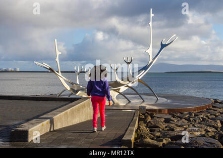 Reykjavík, Islande. 25/05/2018. Météo. Froid, agréable de commencer la journée comme un touriste américain bénéficie de la refléter les rayons du soleil sur le Soleil Voyager le long de la sculpture Solfar Reykjavík' promenade de front de mer. Le monument d'une sculpture en acier massif par Jón Gunnar Arnason qui peut ressembler à un bateau viking, mais en fait, un rêve voile et ode au soleil. /AlamyLiveNews MediaWorldImages Crédit : Banque D'Images