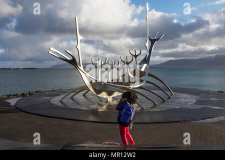 Reykjavík, Islande. 25/05/2018. Météo. Froid, agréable de commencer la journée comme un touriste américain bénéficie de la refléter les rayons du soleil sur le Soleil Voyager le long de la sculpture Solfar Reykjavík' promenade de front de mer. La vue d'une sculpture en acier massif par Jón Gunnar Arnason qui peut ressembler à un bateau viking, mais en fait, un rêve voile et ode au soleil. /AlamyLiveNews MediaWorldImages Crédit : Banque D'Images