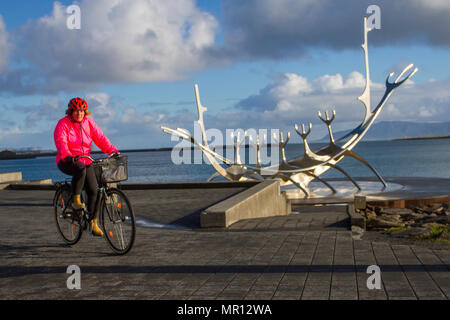 Drakkar Viking à Reykjavík, Islande. 25/05/2018. Météo. Froid, agréable de commencer la journée comme un touriste américain bénéficie de la refléter les rayons du soleil sur le Soleil Voyager le long de la sculpture Solfar Reykjavík' promenade de front de mer. La vue d'une sculpture en acier massif par Jón Gunnar Arnason qui peut ressembler à un bateau viking, mais en fait, un rêve voile et ode au soleil. /AlamyLiveNews MediaWorldImages Crédit : Banque D'Images