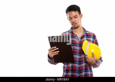 Studio shot of young Asian man construction worker reading sur cl Banque D'Images