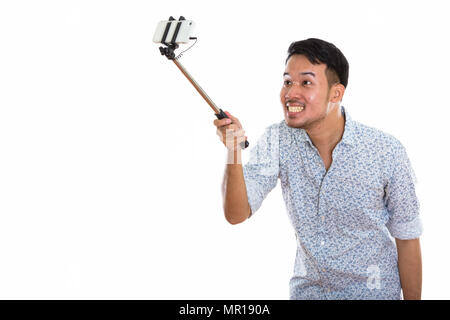 Young happy Asian man smiling et prendre photo selfies avec mob Banque D'Images