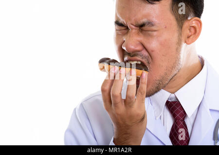 Close up of young Asian man eating donut médecin avec les yeux fermé Banque D'Images