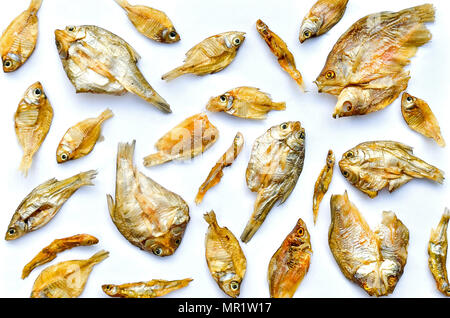 Sécher le poisson du soleil sur le fond blanc, motif de poisson séché et de petits poissons séchés, vue de dessus de sécher le poisson sur le fond blanc pour l'isolement d Banque D'Images