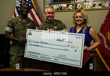 Le sergent du Corps des Marines des États-Unis. Le major Delvin Smythe (à gauche), le sergent-major de la Marine Corps Air Station Yuma (Arizona), et le Colonel Ricardo Martinez (centre), le commandant du MCAS Yuma, présent Lisa Tourtelot (à droite), l'adjoint aux affaires publiques Affaires publiques de MCAS Yuma et Caméra de combat, avec un chèque de cinq cents dollars en plus de la MCAS Yuma employé de la 2e trimestre award au quartier général de la station, le 3 mai 2017. (U.S. Marine Corps photo prise par Lance Cpl. Christian cachola) Banque D'Images