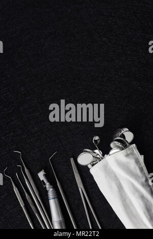 Outils de dentiste sur fond sombre vue d'en haut. les instruments dentaires portant sur le tableau noir Banque D'Images