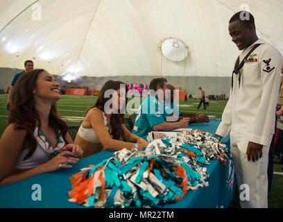 170503-N-GP524-0277 MIAMI (3 mai 2017) Miami Dolphins cheerleaders signer des autographes pour électricien, d'officier de 3e classe Jonas Asiedu, originaire du Ghana, tout en visitant le centre de formation de l'équipe dans le cadre de la 27e Semaine annuelle de Port Everglades. La Semaine de la flotte du Port Everglades est l'occasion pour les citoyens de la Floride du Sud d'être témoin de première main les dernières capacités des services maritimes d'aujourd'hui, et d'acquérir une meilleure compréhension de la façon dont la mer services support la défense nationale des États-Unis. (U.S. Photo par marine Spécialiste de la communication de masse 2e classe Bill Dodge/libérés) Banque D'Images