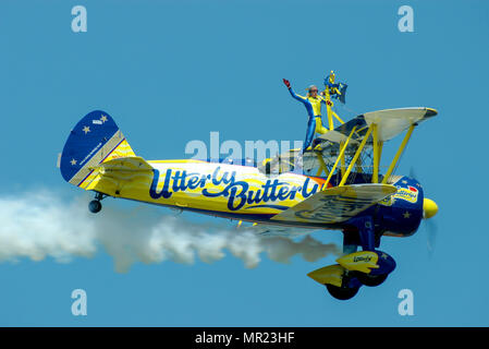 Une équipe de wingwalking sponsorisée par Butterly. Fille sur l'aile, aile marchant. Marcheur d'aile femelle. Wingwalker. Voler à un spectacle aérien. Ciel bleu Banque D'Images