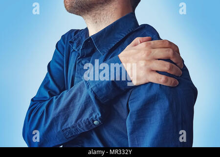 Businessman holding sa main à son mal de dos. Un jeune homme en chemise bleue se plaint de douleurs à l'épaule. fracture de l'avant-bras. concept de il Banque D'Images