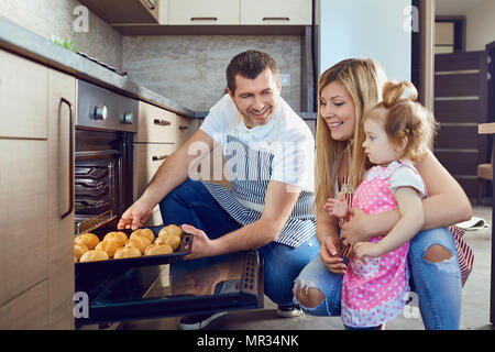 La famille va prendre un bac avec les cookies du four. Banque D'Images