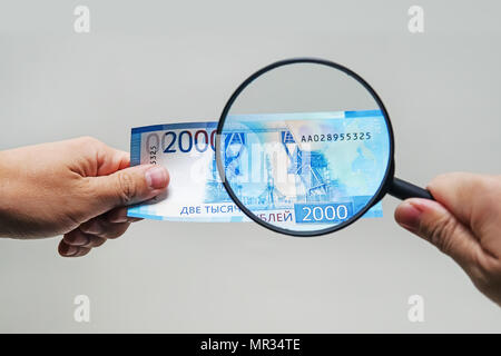 Loupe d'experts vérifie l'argent suspect. Recherchez des filigranes sur du papier de faux billets. loupe, loupe, loupe, magn Banque D'Images