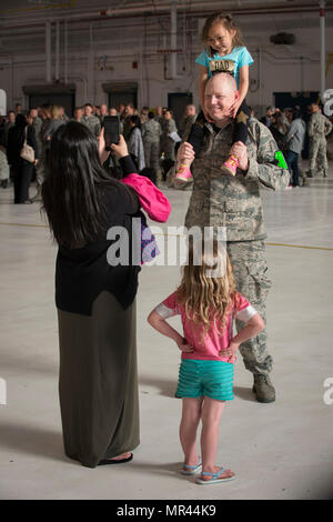 Tech. Le Sgt. Michael Demonbrun du Colorado Air National Guard's 140e Escadron de maintenance des aéronefs, pose pour une photo prise par sa femme Stef avec leur fille qu'à son amie Elli Alysaa regarde sur Isaac, avant la 140e de Buckley AFB, Colorado, le 5 mai 2017. Environ 250 aviateurs du Colorado Air National Guard avec aile du 140E 12 F-16 Fighting Falcon sont partant à Kadena Air Base, le Japon pour un déploiement à l'appui des forces américaines du Pacifique Theatre de mesures de sécurité. (U.S. Air National Guard photo par le Sgt. Wolfram M. Stumpf/libérés) Banque D'Images