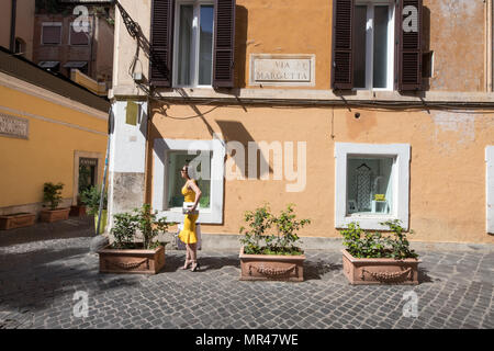 Rome Via Margutta, la rue des artistes famouse, actractive femme avec robe de chambre jaune et panier en attente dans la rue. Scène Rome Italie Banque D'Images