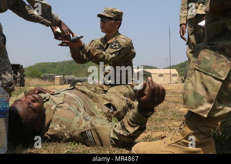 La FPC. YongHyun Lee, un natif de Dallas, au Texas, affectés au siège et le siège batterie, 210e Brigade d'artillerie, 2e Division d'infanterie/Combinés américano-Division, reçoit du matériel médical à démontrer comment effectuer des soins médicaux à une victime simulée sur le terrain lors d'un entraînement physique à LTA130, Corée du Sud, le 3 mai 2017. La semaine offre des possibilités de formation des soldats FTX dans une simulation de combat. (U.S. Photo de l'armée par le Cpl. Michelle U. Blesam, 210e FA Bde PAO) Banque D'Images
