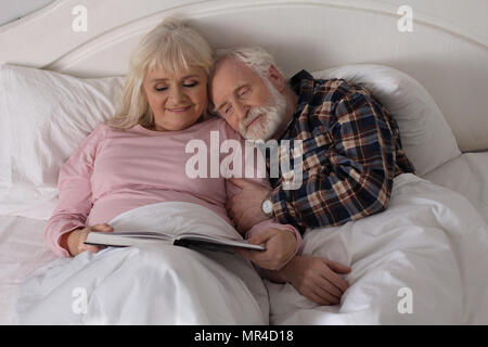 Vieux couple lire au lit. Banque D'Images