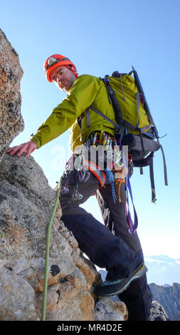 Guide de montagne mâle sur une escalade de granite ridge exposés dans les Alpes Banque D'Images