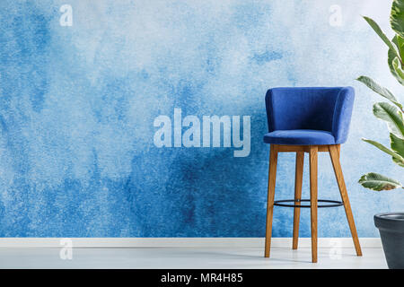 Tabouret de bar debout dans un salon intérieur à côté d'une fleur située sur un mur vide peintes à l'aquarelle. Positionnement de votre produit Banque D'Images