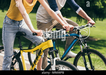 Cropped shot of couple riding bicycles together in park Banque D'Images