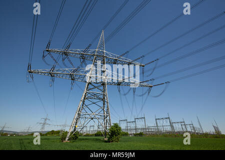 Le pylône d'alimentation avec les lignes électriques et postes de transformation sous ciel bleu en Allemagne Banque D'Images
