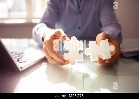 Close-up of Entrepreneur's Hand Holding Two White Jigsaw Puzzle Plus de 24 Banque D'Images