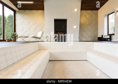 Luxueux salon avec cheminée et canapé blanc Banque D'Images