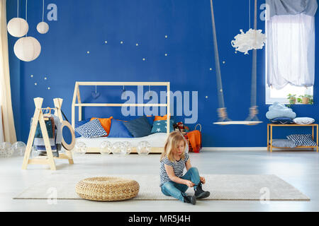 Girl chambre avec mur bleu, swing, porte manteau et double