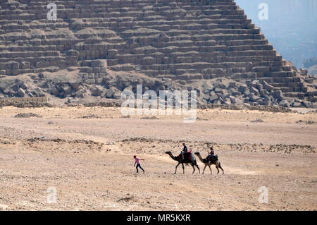 Les chameaux équitation à proximité de la grande pyramide de Gizeh (pyramide de Chéops ou pyramide de Kheops) ; plus ancienne et la plus grande des trois pyramides dans la pyramide de Gizeh en Égypte complexe. C'est le plus ancien des sept merveilles du monde antique, et le seul à rester en grande partie intacte. Achevée vers 2560 BC. Banque D'Images