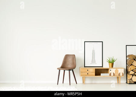 Armoire rustique avec des plantes et de l'affiche entre brown président et le bois de sciage dans le salon intérieur avec copie espace Banque D'Images