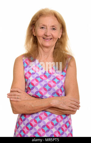 Studio shot of senior woman smiling with arms crossed Banque D'Images