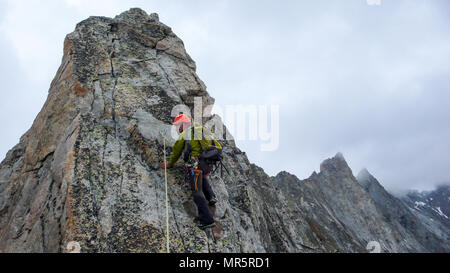 Guide de montagne mâle sur une escalade de granite ridge exposés dans les Alpes Banque D'Images