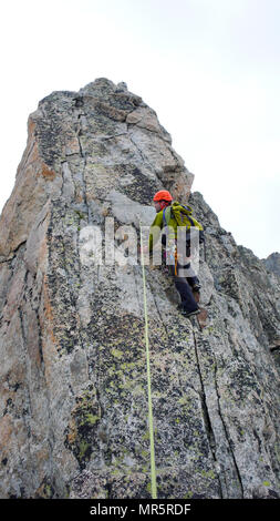 Guide de montagne mâle sur une escalade de granite ridge exposés dans les Alpes Banque D'Images