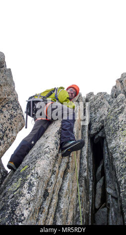 Guide de montagne mâle sur une escalade de granite ridge exposés dans les Alpes Banque D'Images