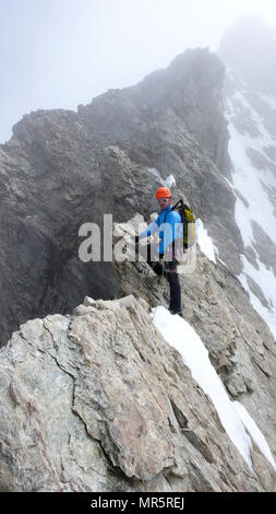 Guide de montagne mâle sur une escalade de granite ridge exposés dans les Alpes Banque D'Images