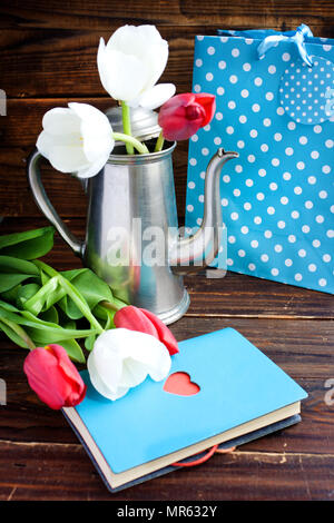 Bouquet de tulipes, pot de café et un sac-cadeau, le bloc-notes avec cœur sur fond de bois Banque D'Images