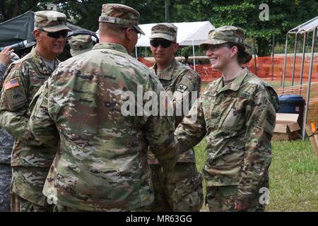 Le Sgt commande. Le major Angel Rivera et le Colonel John Simma, qui servent tous deux avec le 210e Groupe de soutien régional à partir de Puerto Rico, présenter un cadeau de la fête des mères à slt Danielle Meyer, un natif du Wyoming Evanston, qui sert d'infirmière pour la garde nationale de Wyoming Détachement médical. Meyer et un personnel de professionnels médicaux ont été l'administration des soins de santé gratuitement pendant au-delà de l'horizon 2017. (Photo par le Sgt. 1re classe Whitney Houston) Banque D'Images