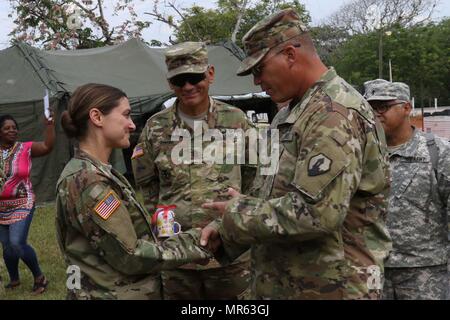 Le Sgt commande. Le major Angel Rivera et le Colonel John Simma, qui servent tous deux avec le 210e Groupe de soutien régional à partir de Puerto Rico, présenter un cadeau de la fête des Mères au Capitaine Anne-Marie Octavio, qui sert comme infirmière praticienne pour la garde nationale de Wyoming Détachement médical. Octavio et un personnel de professionnels médicaux ont été l'administration des soins de santé gratuitement pendant au-delà de l'horizon 2017. (Photo par le Sgt. 1re classe Whitney Houston) Banque D'Images