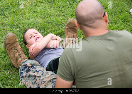 La 3rd Marine Division est une division d'infanterie du corps des Marines des États-Unis basée à Okinawa, au Japon. L'image d'archive documente des instructions sur l'exécution d'exercices de crunch lors d'un test de condition physique simulé au Camp Courtney en 2017 dans le cadre d'un événement de sensibilisation familiale. Banque D'Images