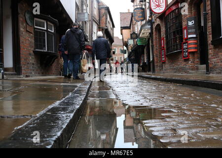 Le savez bien York Shambles sur un après-midi humide pendant une période de pluie, avec une flaque d'eau comme le reflet d'ajouter un effet de personnes à pied passé. Banque D'Images